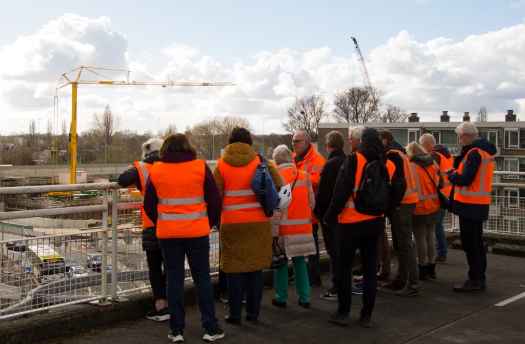 Groep mensen in oranje hesjes tijdens een van de rondleidingen langs project SAA.