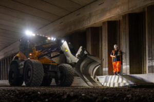 een shovel staat in het midden, in het donker, werkzaamheden uit te voeren.